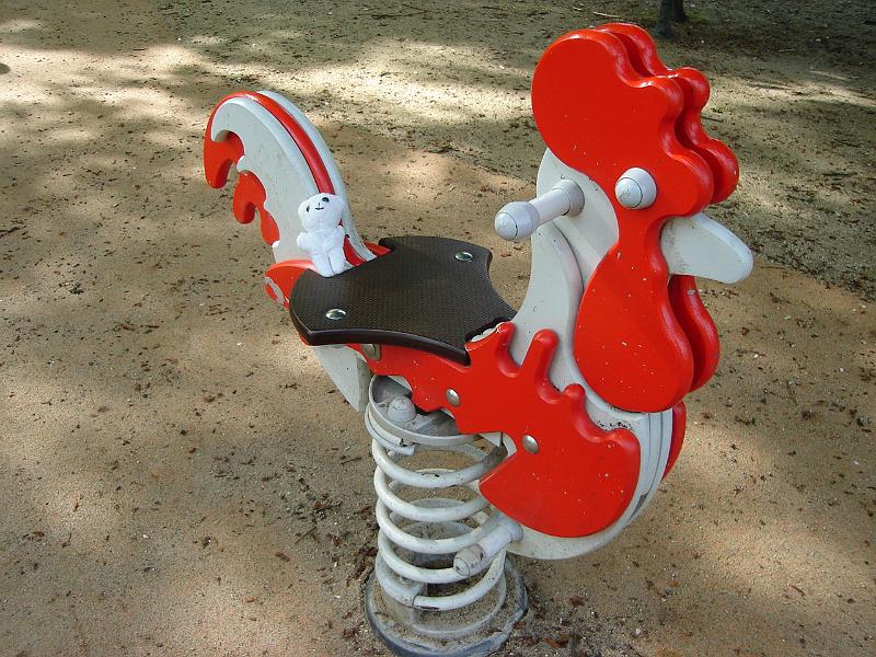 DSC02610.JPG - The Sweet Baboo checks out a rooster in a playground.  Chartres France 26 April 2008