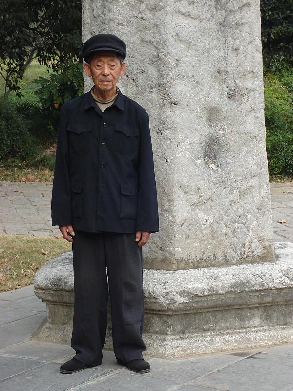 DSC02242.JPG - An 81 year old Chinese man willing to pose for a photograph by a stone pillar. 28 October 2009