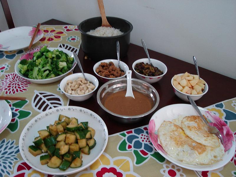 DSC02275.JPG - Lunch prepared by Brenda: steamed broccoli, cashews, cucumbers with a sauce, eggs, apples, raisins, strange taste horse beans, and rice with a peanut sauce. 29 October 2009