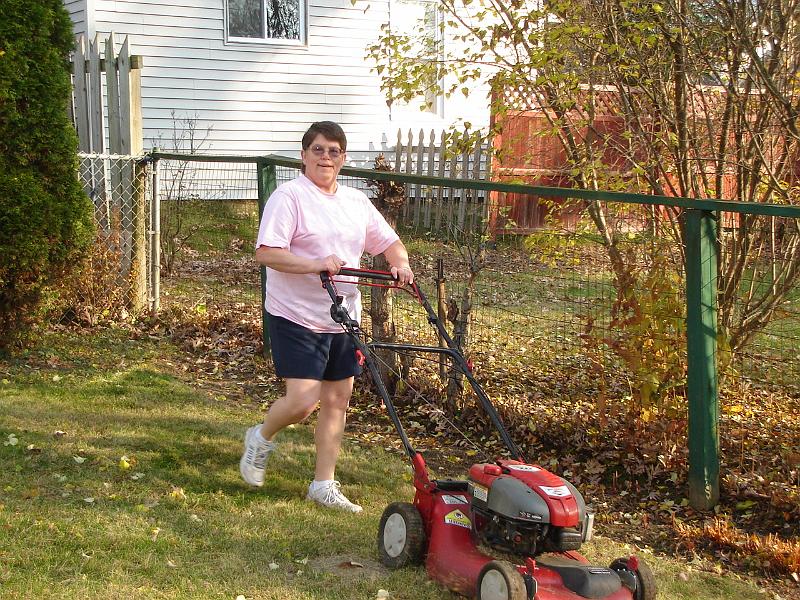 DSC02608.JPG - Sandy mowing our lawn after she was unable to empty her mower gas tank while mowing her lawns for the last time this season. 8 November 2009