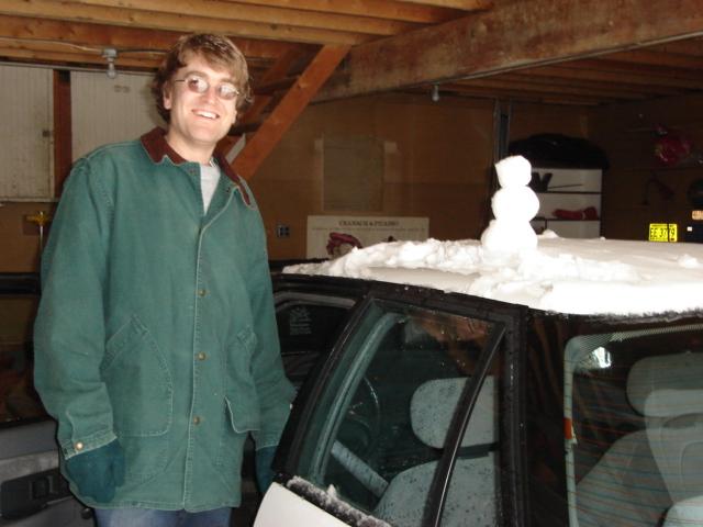 DSC00218.JPG - Andrew leaving for Urbana after making a tiny snowman from the snow on the roof of his car. 5 March 2006.