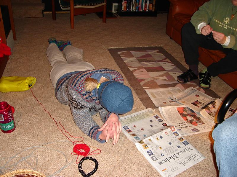 DSC00257.JPG - Gretchen does not know whether to knit or read about mascots. 23 March 2006