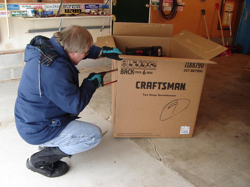 DSC02150.JPG - After numerous record breaking snowfalls - we decided we needed a serious snow blower for the heavy wet deep snows.  Otherwise we shovel - and love it.  Here is Bill using a hack saw to open the box.  We have named it Thor. 9 December 2007