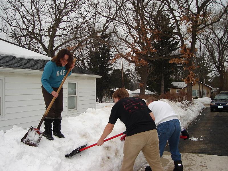 DSC02278.JPG - Sara, Andrew, and Bill moving snow piles to reduce snow between houses. 2 March 2008