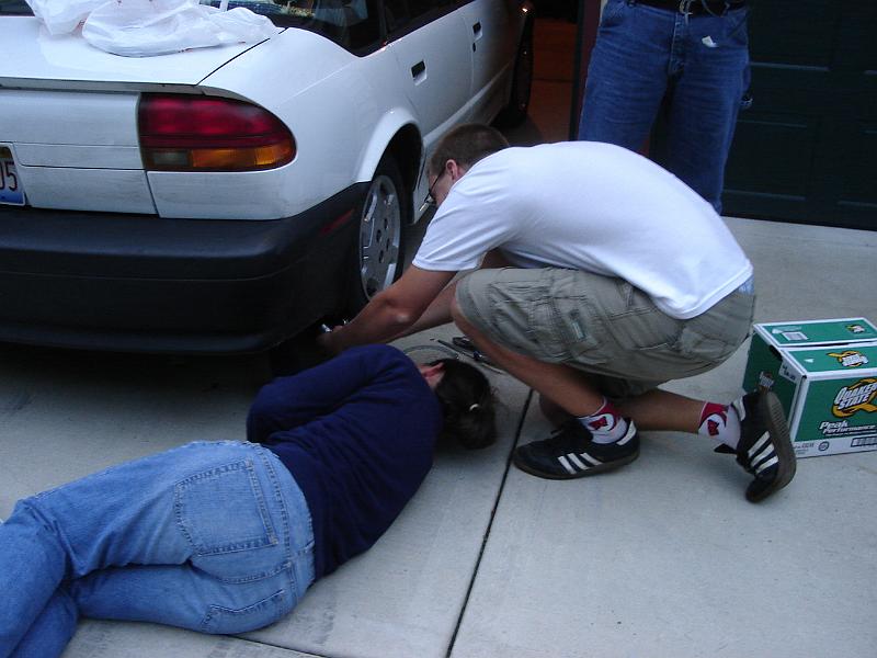 DSC00268.JPG - Brenda fixing the muffler and Andrew holding a flashlight.  Note: it has been reported that said muffler made it all the way to Minneapolis and back to Urbana! 14 September 2008