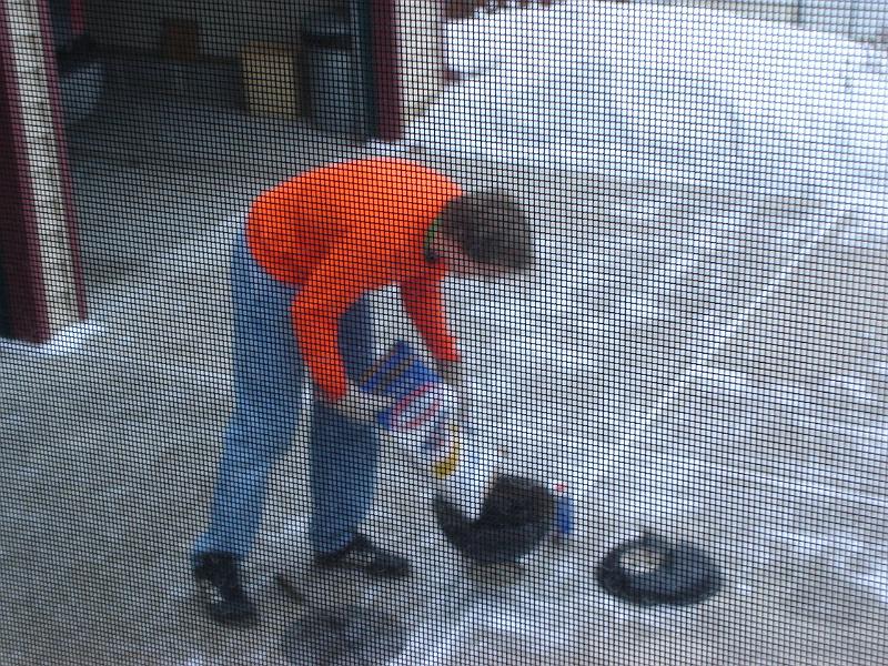 DSC00741.JPG - Breakfast outside on New Year's Day 2009 in Wisconsin.  Andrew loading up the coals. 1 January 2009