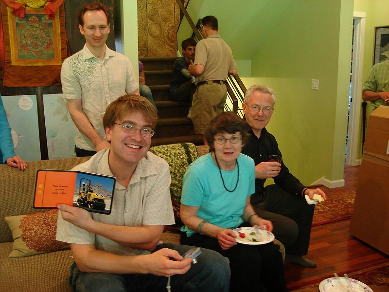 DSC00987.JPG - Andrew with a GREAT book on the couch with Viv and Ian. 3 May 2009